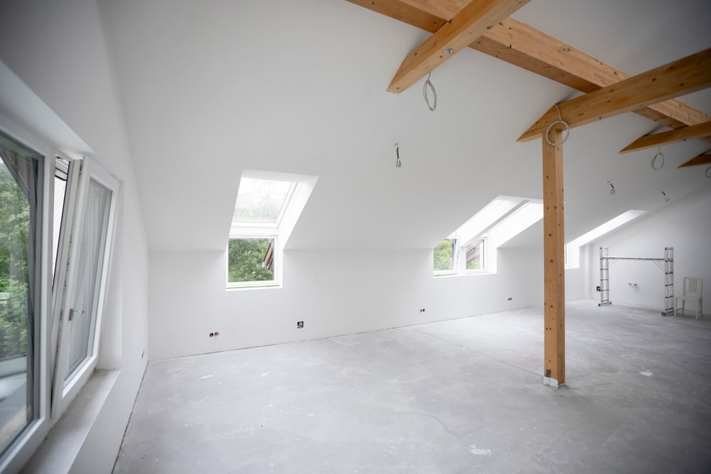 freshly painted white room interior of a resident with brown wooden beams 