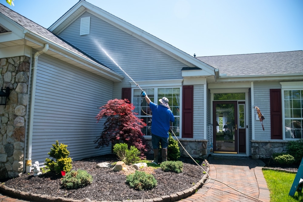 professional painting company power washing a home before painting 