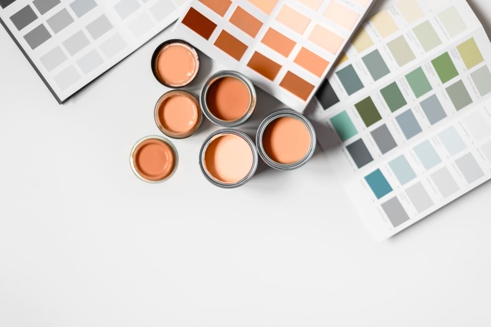 paint samples with multiple colors on swatches and in paint bins of orange and greens and blues