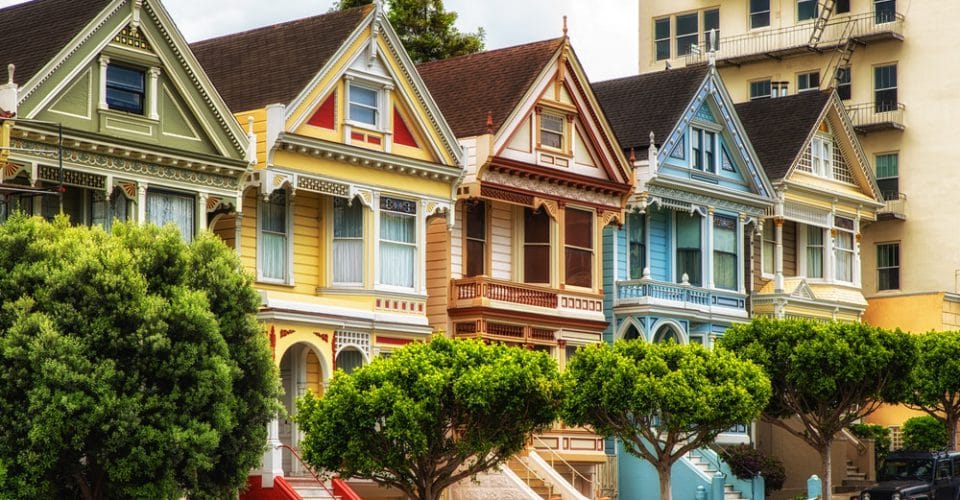 Paint Color Schemes for Victorian Homes featuring green, yellow tan, blue victorian homes in a row 