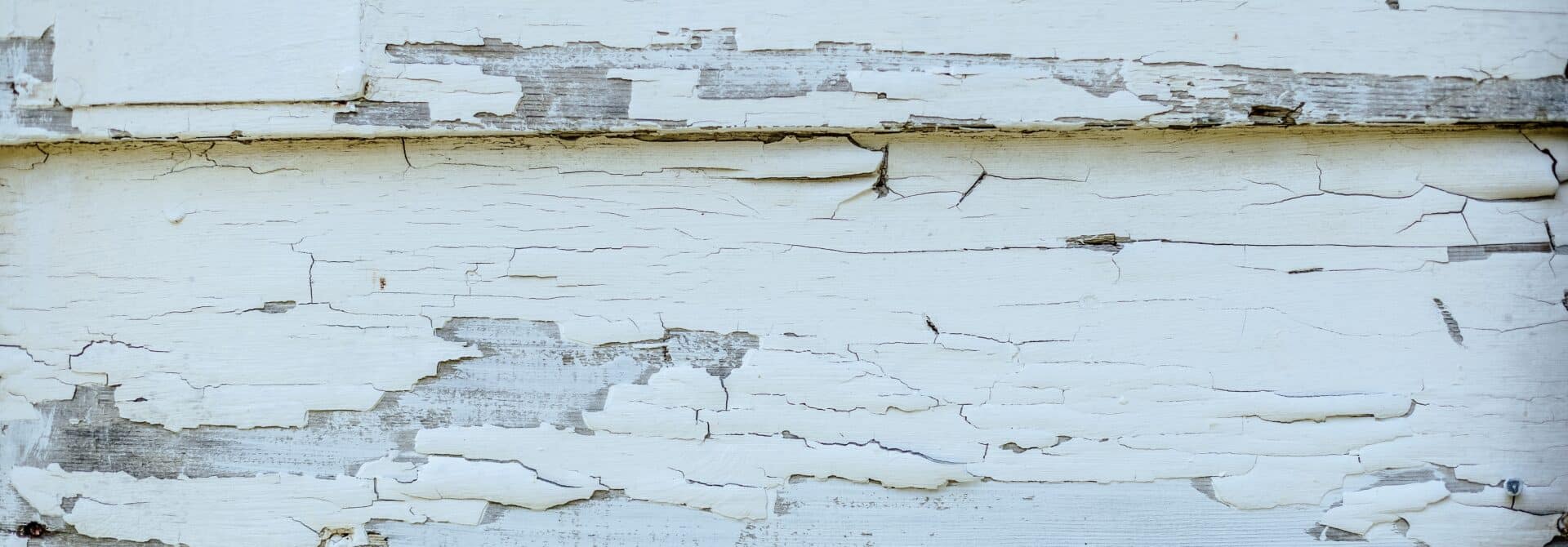 white lead paint peeling from wooden building